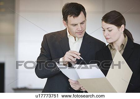Businesspeople reading looking at paperwork View Large Photo Image Stock Image - Businesspeople reading looking at paperwork. Fotosearch