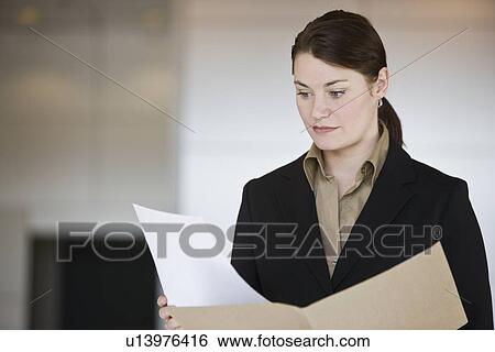 Businesswoman reading paperwork View Large Photo Image Stock Photograph - Businesswoman reading paperwork. Fotosearch