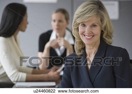 Businesswoman with co-workers in background View Large Photo Image Stock Image - Businesswoman with co-workers in background. Fotosearch