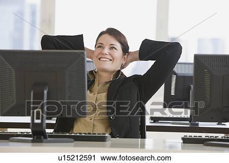 Stock Image - Businesswoman with hands behind head. Fotosearch