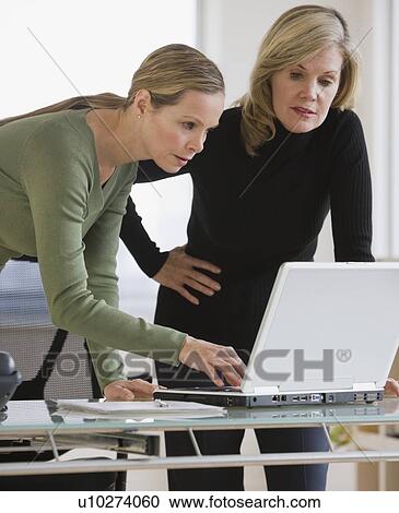 Businesswomen looking at laptop View Large Photo Image Stock Image - Businesswomen looking at laptop. Fotosearch