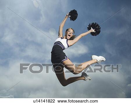 Cheerleader with pom poms jumping View Large Photo Image Stock Image - Cheerleader with pom poms jumping. Fotosearch