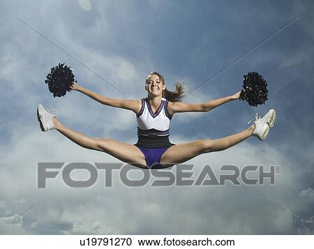 Stock Image - Cheerleader with pom poms jumping. Fotosearch