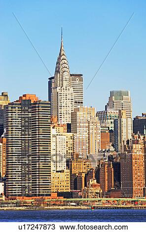 Stock Image - City skyline along water. Fotosearch