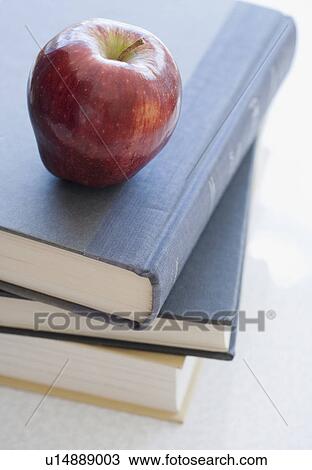 Stock Image - Close up of apple on stack of books. Fotosearch