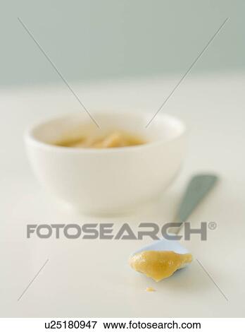 Stock Photo - Close up of baby food and spoon. Fotosearch