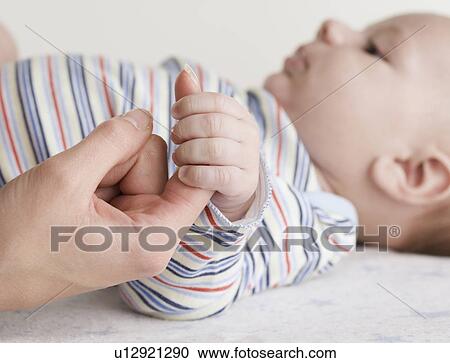 Close up of baby holding mother’s hand View Large Photo Image Stock Image - Close up of baby holding mother’s hand. Fotosearch