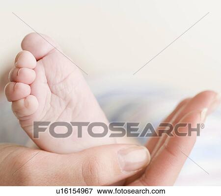 Close up of baby’s foot in mother’s hand View Large Photo Image Stock Photo - Close up of baby’s foot in mother’s hand. Fotosearch