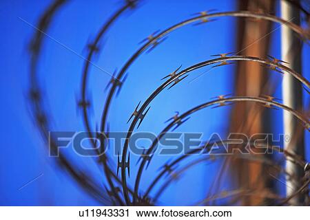 Stock Image - Close up of coiled razor wire. Fotosearch