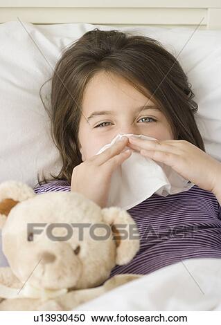 Close up of girl blowing nose in bed View Large Photo Image Stock Image - Close up of girl blowing nose in bed. Fotosearch