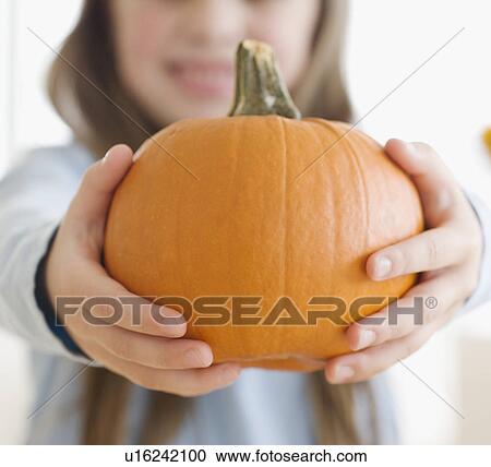 Close up of girl holding pumpkin View Large Photo Image Stock Image - Close up of girl holding pumpkin. Fotosearch