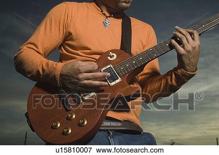 Stock Photo - Close up of man playing guitar. Fotosearch