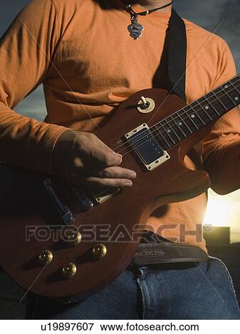 Close up of man playing guitar View Large Photo Image Stock Photo - Close up of man playing guitar. Fotosearch