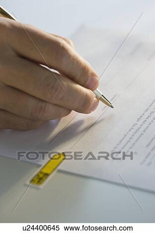 Stock Photography - Close up of man signing paperwork. Fotosearch