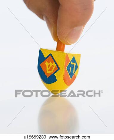 Close up of man spinning dreidel View Large Photo Image Stock Photo - Close up of man spinning dreidel. Fotosearch