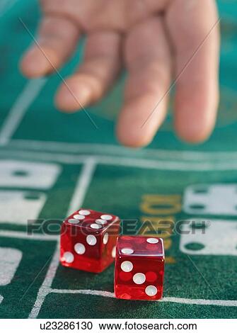 Stock Image - Close up of man throwing dice. Fotosearch