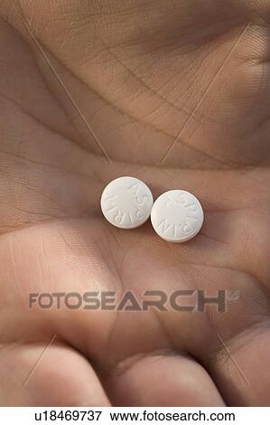 Stock Photo - Close up of medication in man’s hand. Fotosearch