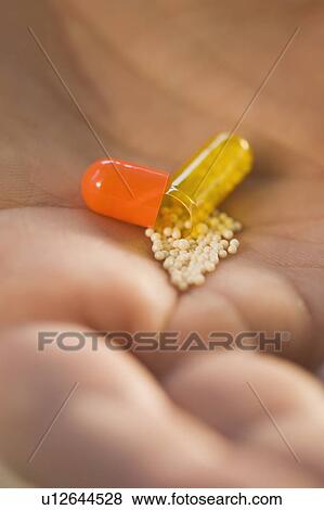 Close up of open medication capsule in man’s hand View Large Photo Image Stock Photo - Close up of open medication capsule in man’s hand. Fotosearch