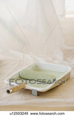 Stock Photo - Close up of paint roller in tray. Fotosearch