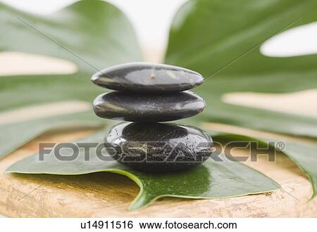 Stock Photograph - Close up of stack of stones on leaf. Fotosearch