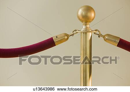 Stock Photograph - Close up of velvet rope and stanchion. Fotosearch