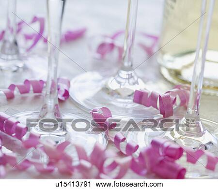 Stock Image - Close up of wine glasses and curled ribbon. Fotosearch