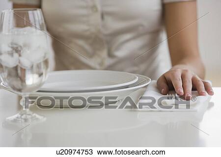 Stock Image - Close up of woman sitting at table. Fotosearch