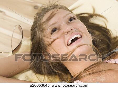 Close up of young woman laying on floor smiling View Large Photo Image Stock Photography - Close up of young woman laying on floor smiling. Fotosearch