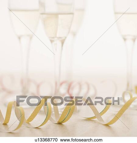 Stock Image - Closeup of champagne glasses with confetti. Fotosearch