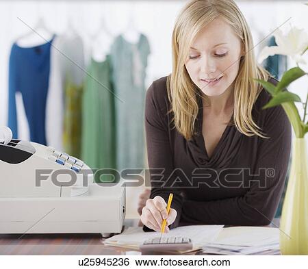 Clothing store sales clerk doing paperwork View Large Photo Image Stock Photograph - Clothing store sales clerk doing paperwork. Fotosearch