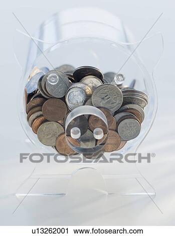 Stock Image - Coins in clear piggy bank. Fotosearch