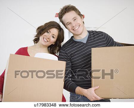 Stock Photo - Couple carrying moving boxes. Fotosearch