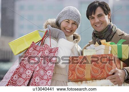 Couple carrying shopping bags and gifts View Large Photo Image Stock Image - Couple carrying shopping bags and gifts. Fotosearch