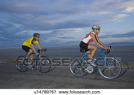 Couple cycling on road, Utah, United States View Large Photo Image Stock Photo - Couple cycling on road, Utah, United States. Fotosearch