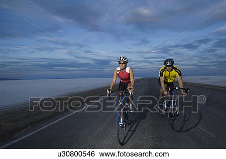 Couple cycling on road, Utah, United States View Large Photo Image Stock Photograph - Couple cycling on road, Utah, United States. Fotosearch