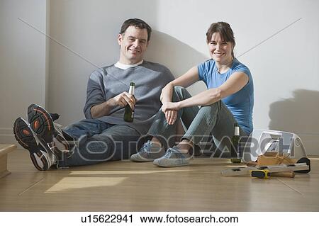 Couple drinking beer on floor View Large Photo Image Stock Image - Couple drinking beer on floor. Fotosearch