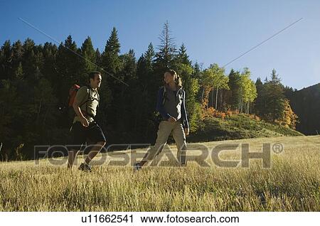 Stock Image - Couple hiking with backpacks, Utah, United States. Fotosearch