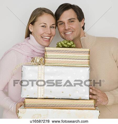 Couple holding pile of gifts View Large Photo Image Stock Photo - Couple holding pile of gifts. Fotosearch