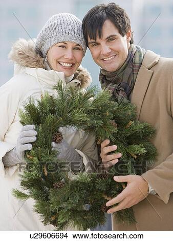 Couple holding wreath View Large Photo Image Picture - Couple holding wreath. Fotosearch