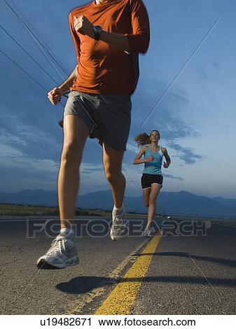 Stock Image - Couple in athletic gear running. Fotosearch