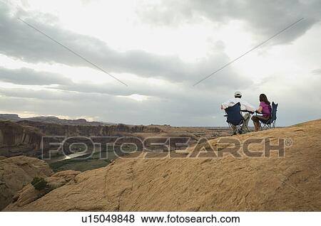 Stock Photo - Couple in camping chairs over-looking canyon. Fotosearch