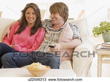 Couple laughing on sofa View Large Photo Image Stock Image - Couple laughing on sofa. Fotosearch