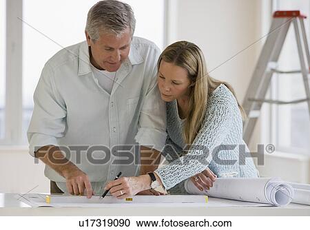 Couple looking at blueprints View Large Photo Image Stock Image - Couple looking at blueprints. Fotosearch