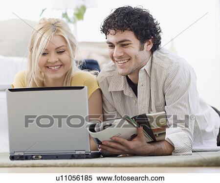 Stock Photography - Couple looking at laptop. Fotosearch