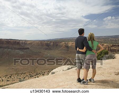 Couple looking over edge of cliff View Large Photo Image Stock Image - Couple looking over edge of cliff. Fotosearch