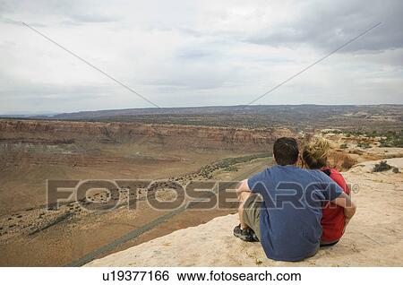 Couple looking over edge of cliff View Large Photo Image Stock Photograph - Couple looking over edge of cliff. Fotosearch