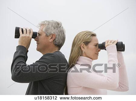 Couple looking through binoculars View Large Photo Image Stock Image - Couple looking through binoculars. Fotosearch