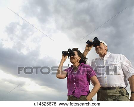 Couple looking through binoculars View Large Photo Image Stock Photo - Couple looking through binoculars. Fotosearch