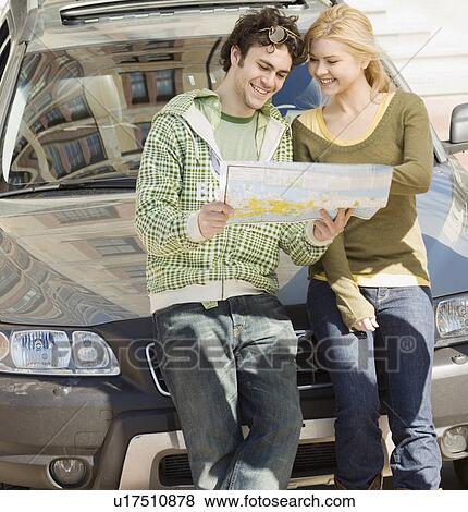 Stock Photo - Couple on front of car looking at map. Fotosearch