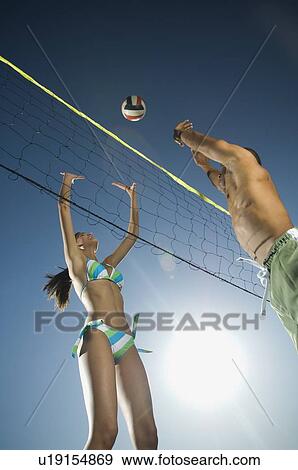 Couple playing beach volleyball View Large Photo Image Stock Photo - Couple playing beach volleyball. Fotosearch